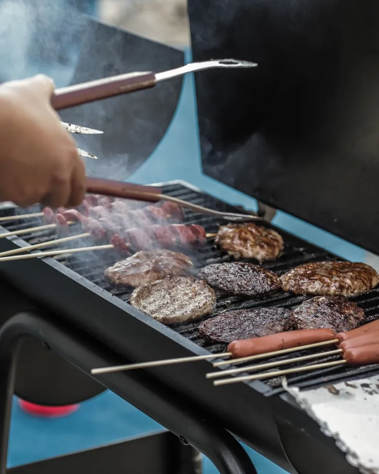 Sausages grilling at an outdoor picnic BBQ
