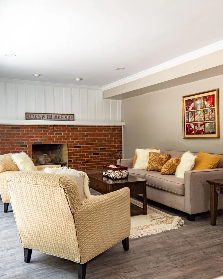 Finished basement living room with comfortable seating and warm lighting