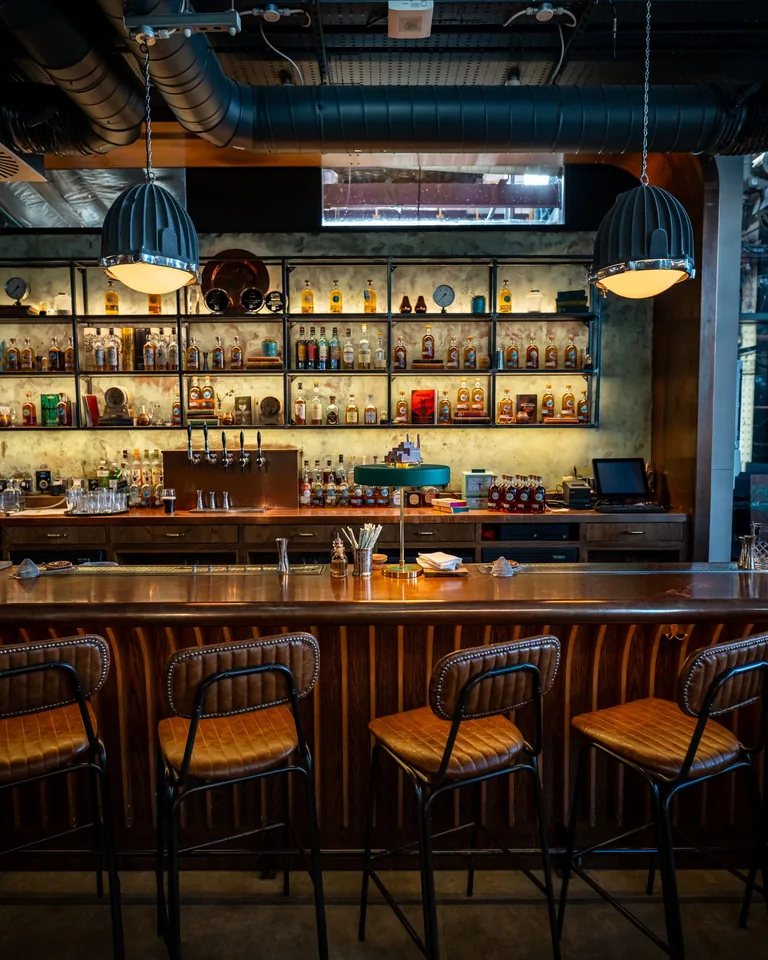 Elegant home bar with stools and backlit shelving