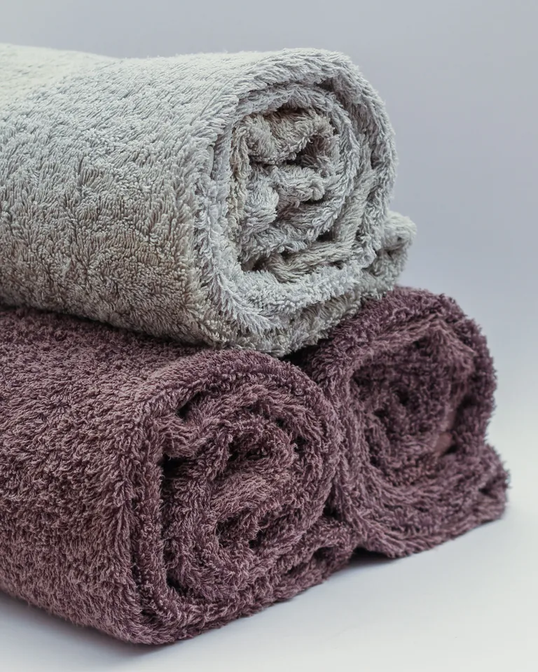 Rolled towels in neutral tones on a shelf