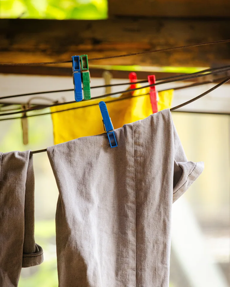 Laundry drying on an outdoor clothesline with colorful pegs
