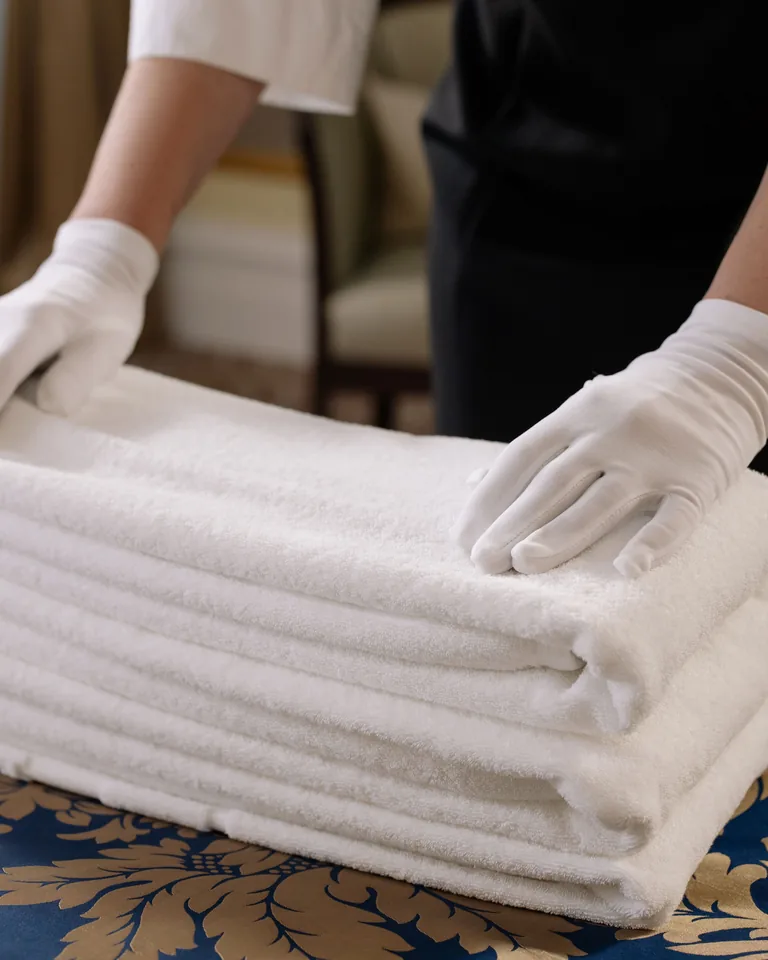 Person holding a stack of clean white towels