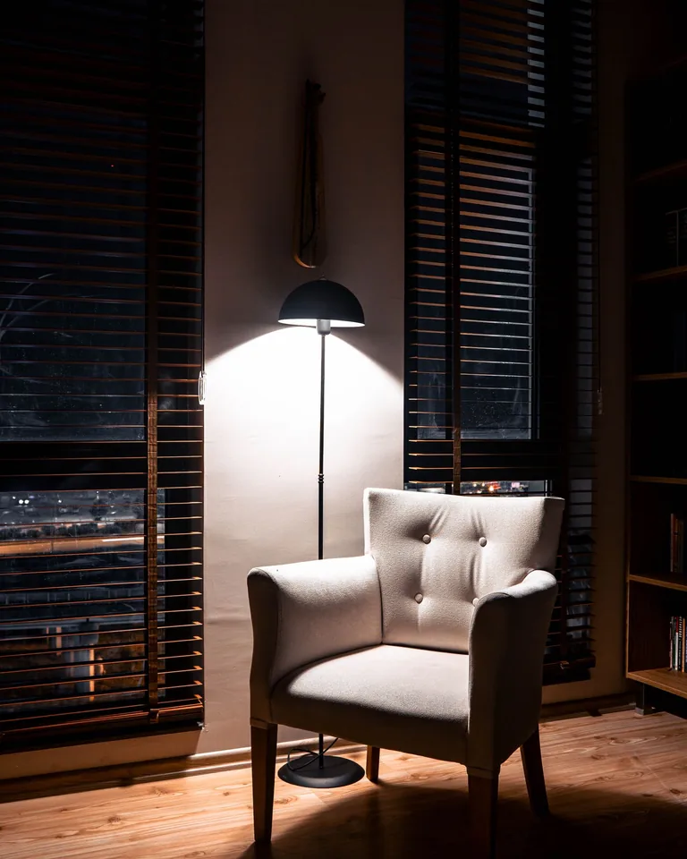 Cozy corner with armchair and warm lamp