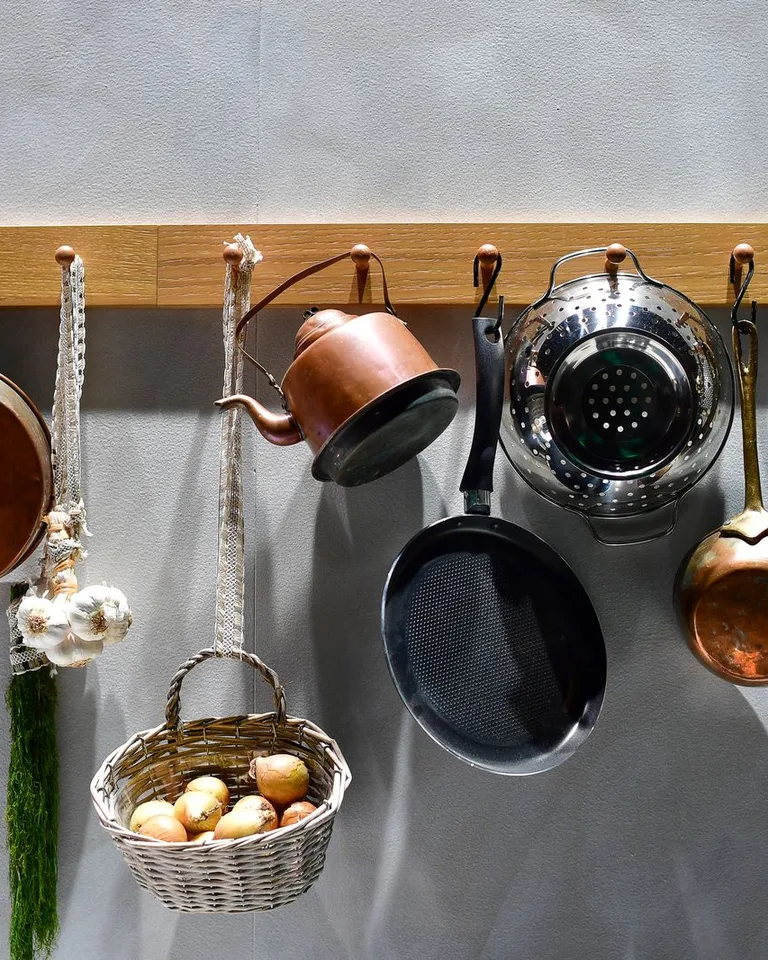 Rustic kitchenware displayed on a wooden rack