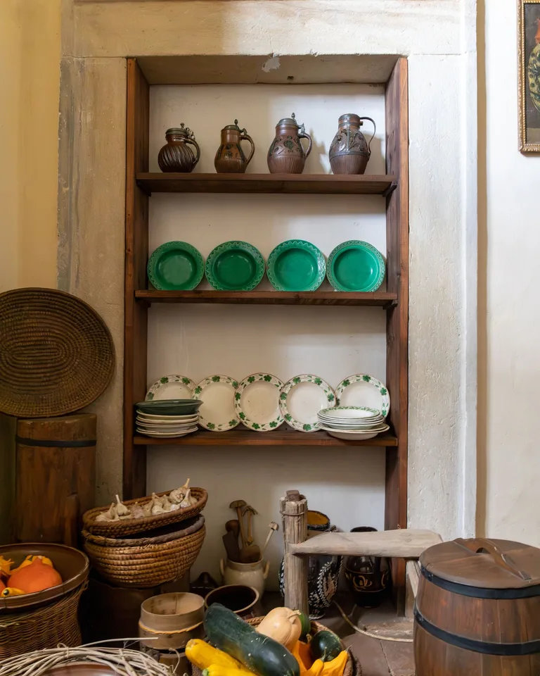 Rustic kitchen shelves displaying pottery and vegetables