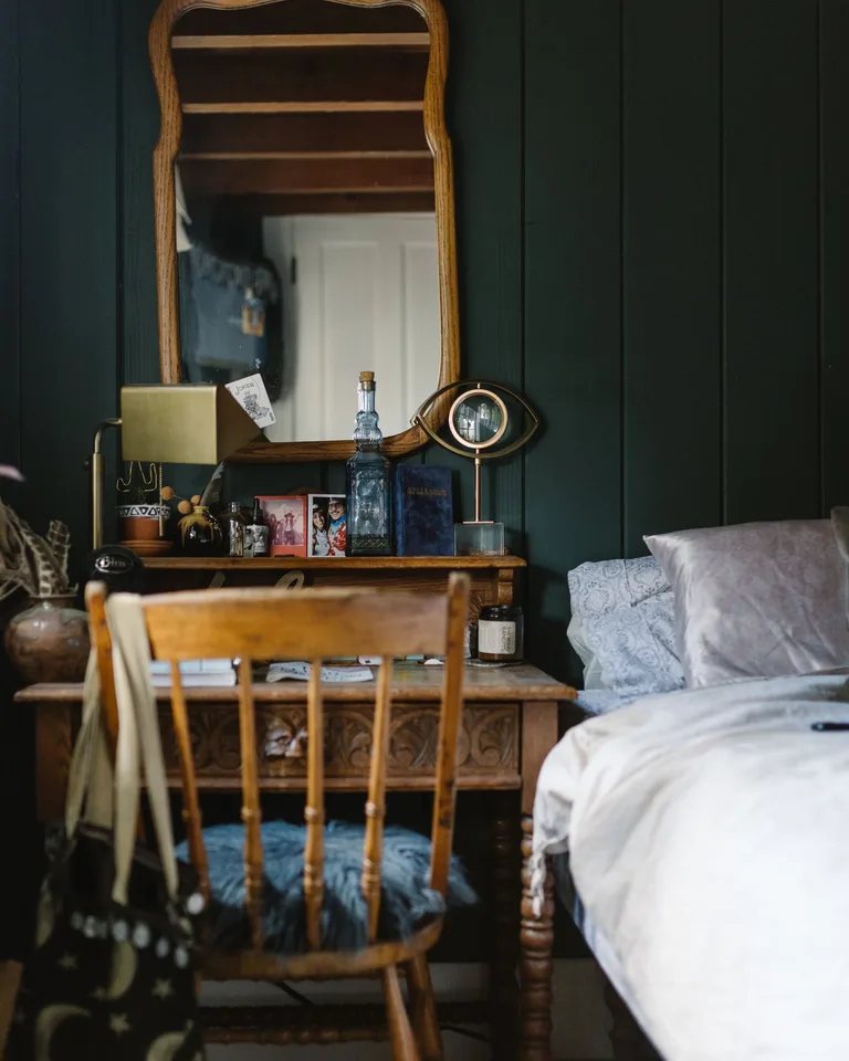 Vintage-style bedroom with ornate wooden furniture and cozy cottagecore bedding