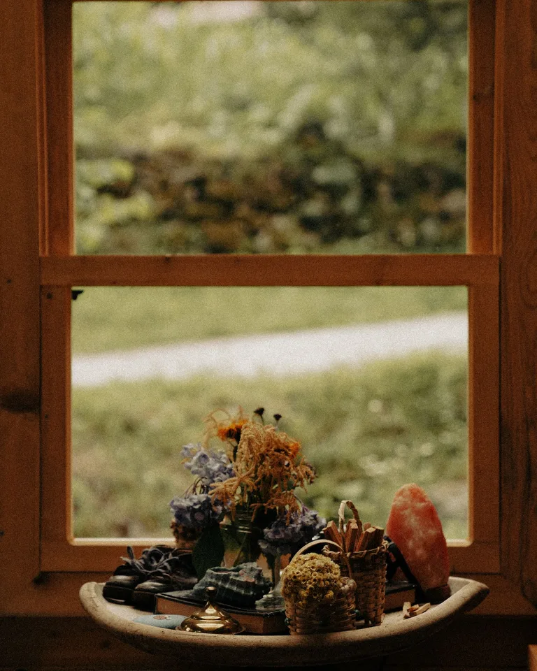 Dried flowers and books styled on a rustic window sill