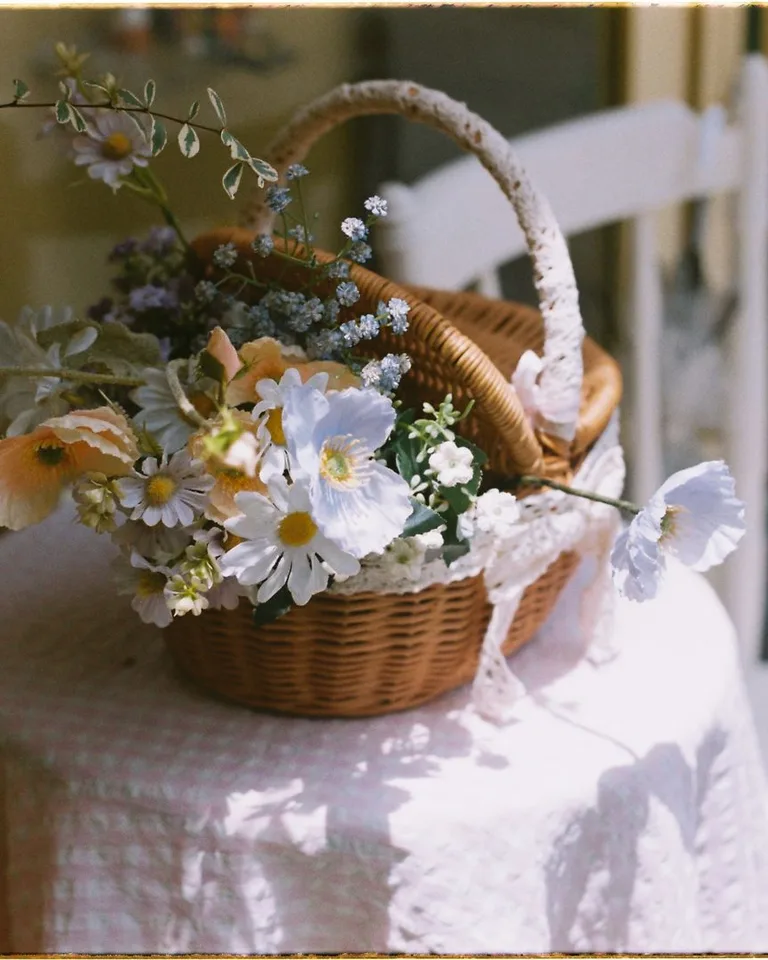 Wicker basket of spring flowers on a lace-covered table