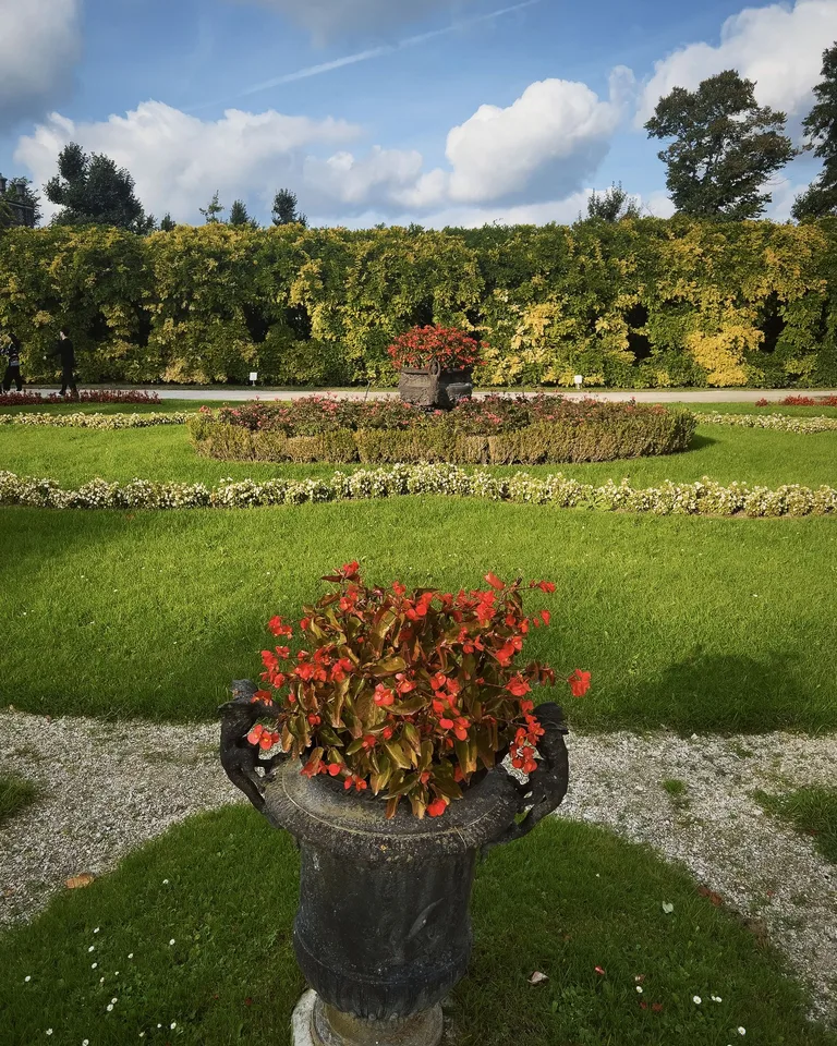 Formal garden with stone urns and lush greenery