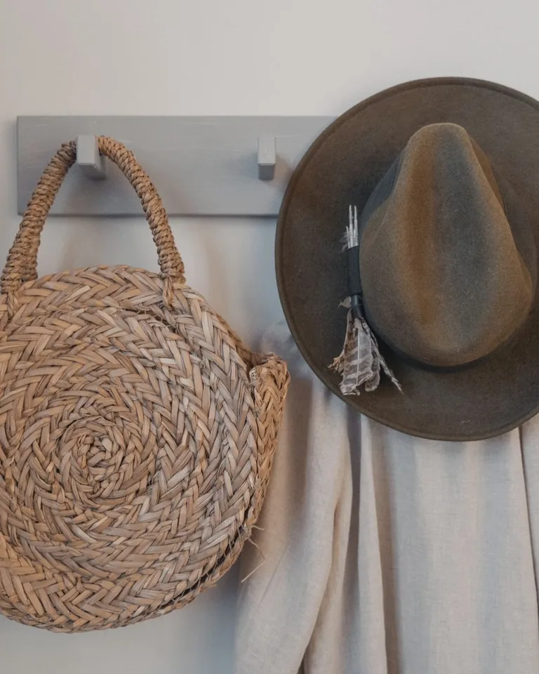 Decorative wall hooks holding bags in an entryway
