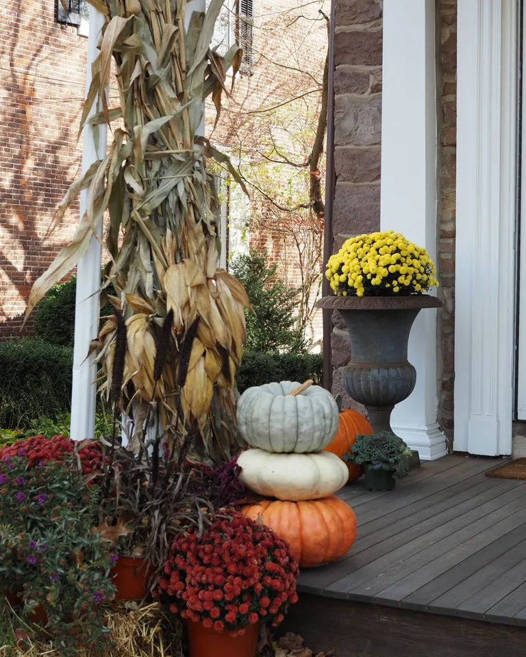Charming fall porch decorated with pumpkins and flowers