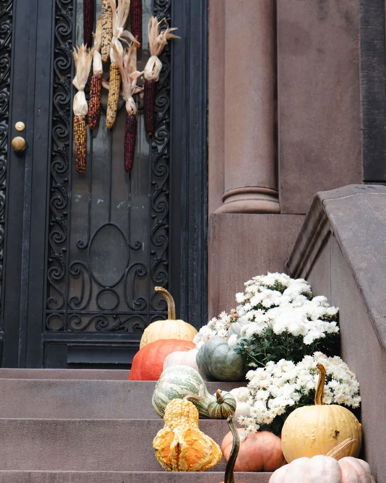 Pumpkins and corn decorating brownstone steps for fall