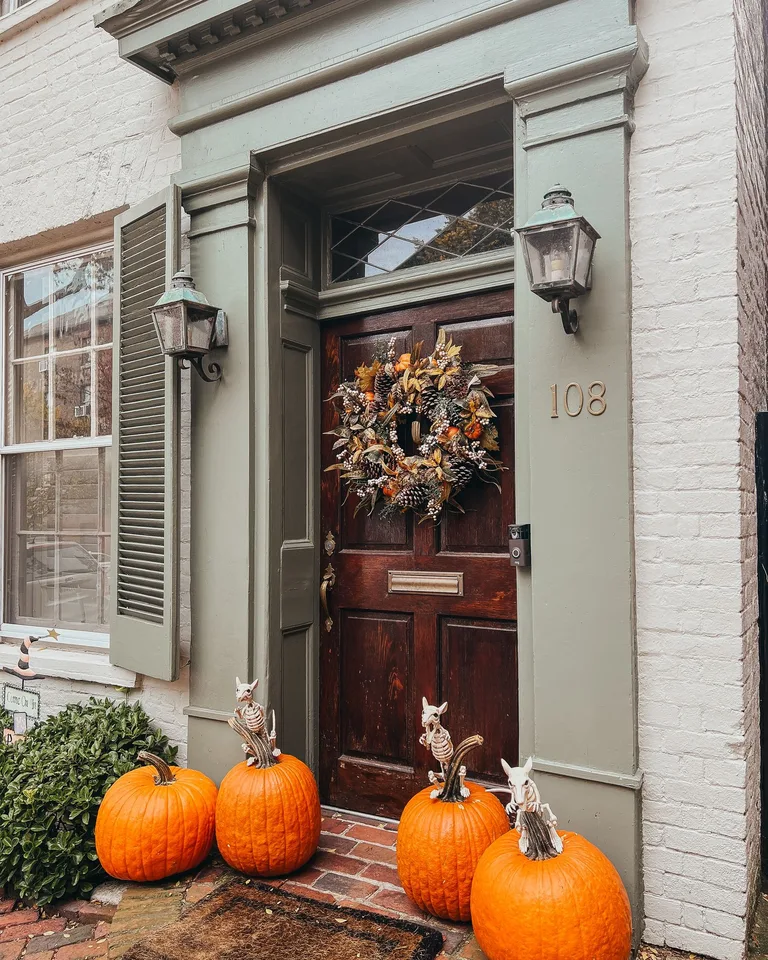 Elegant doorway adorned with pumpkins and an autumn wreath