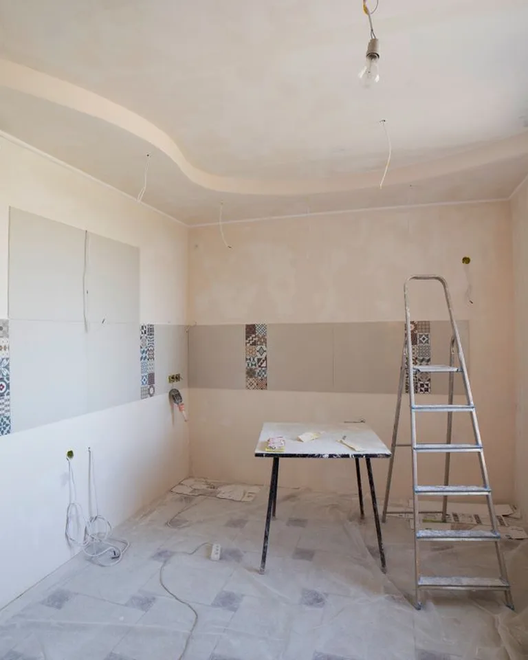 Homeowner reviewing renovation plans inside a house under remodel