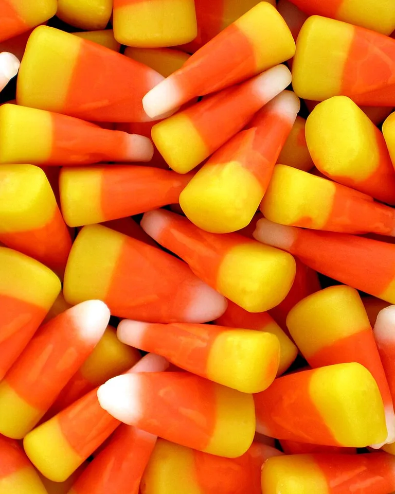 Fence posts painted like giant candy corn for Halloween