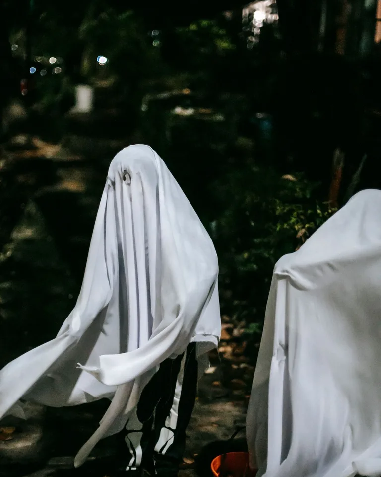 Children dressed as white sheet ghosts for Halloween