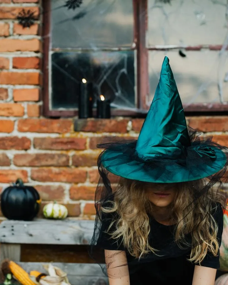 Woman wearing a witch hat with pumpkins, Halloween luminary inspiration