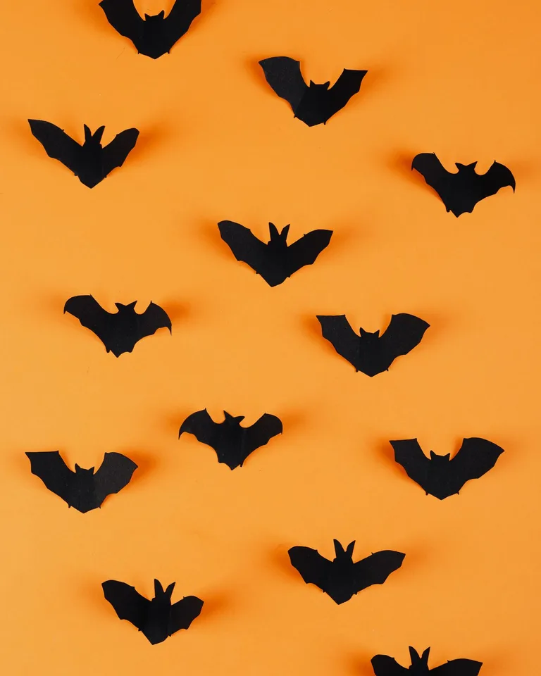 Black bat silhouettes on an orange Halloween background