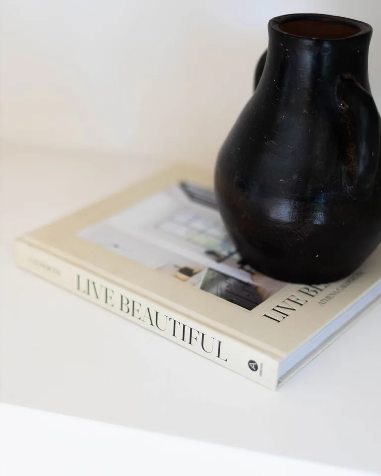 Styled slim console table behind a sofa with decor