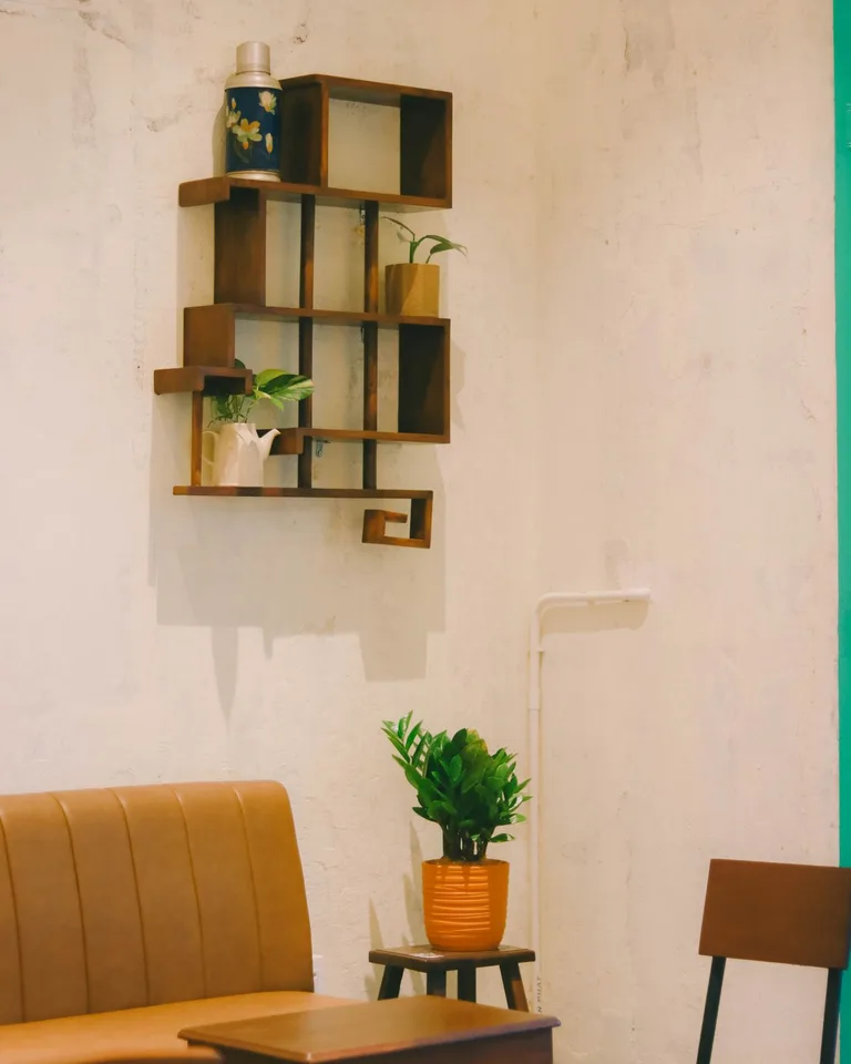 Wooden floating shelves styled in a small room corner