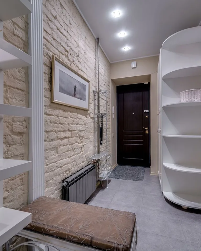 Minimalist entryway with a storage bench and wall shelving