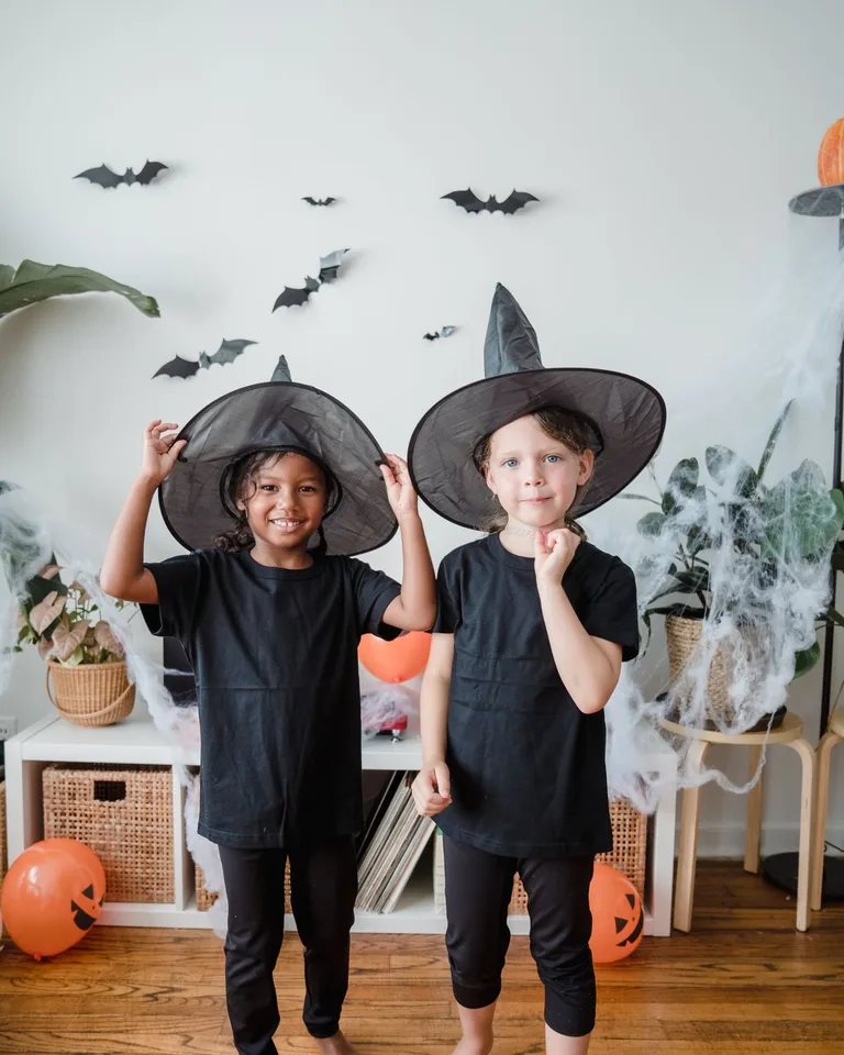 Kids in witch hats posing for a Halloween photo