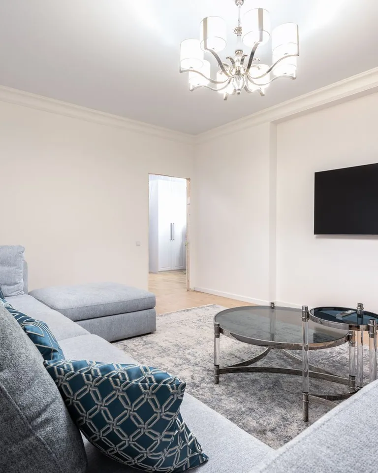 Contemporary room interior with a couch under a shiny chandelier