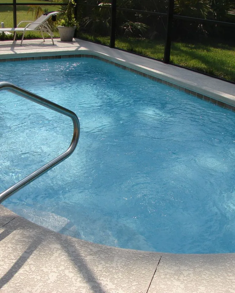 Clean blue swimming pool in a sunny backyard