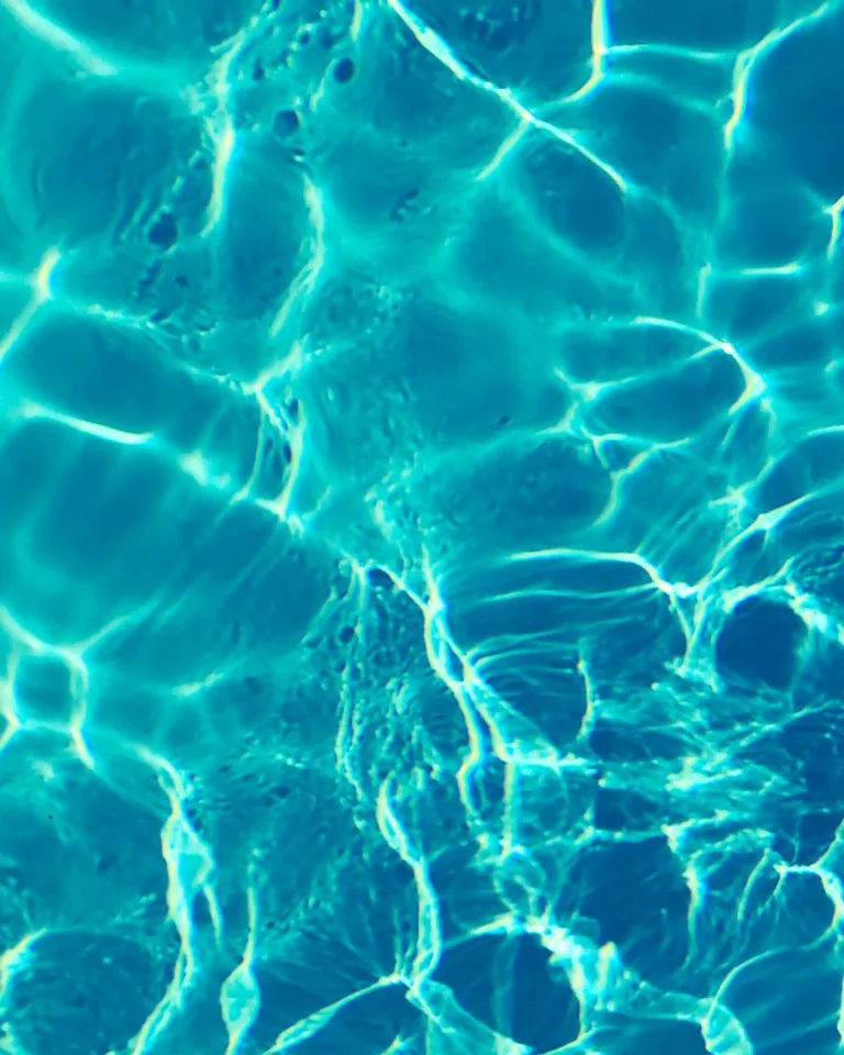 Bright turquoise pool water surface in sunlight