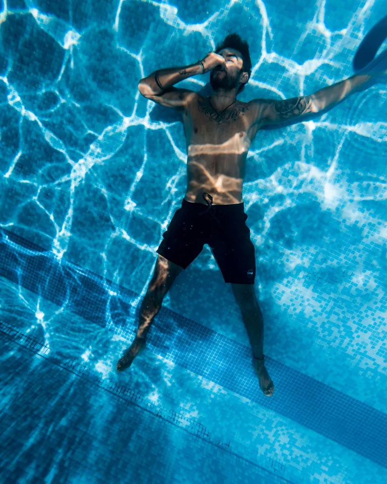 Swimmer submerged in blue pool water