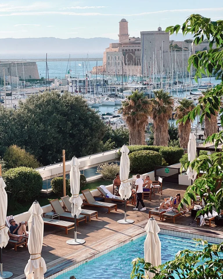 People relaxing on deckchairs by a swimming pool