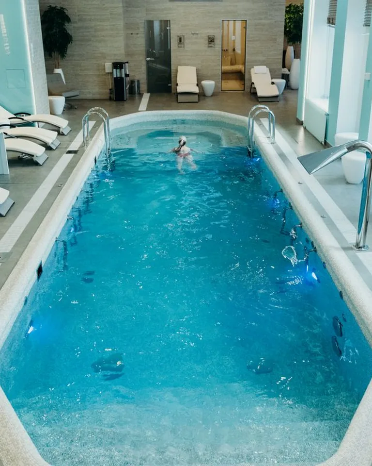 Bright indoor spa pool with lounge chairs