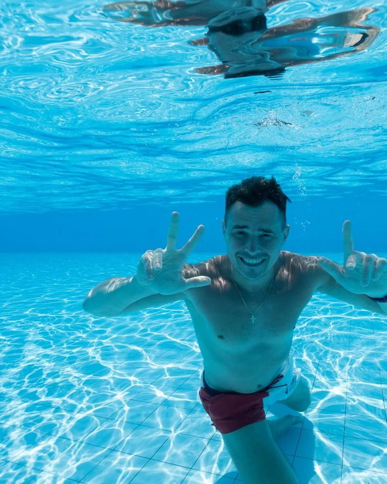 Man diving into a swimming pool on a sunny day