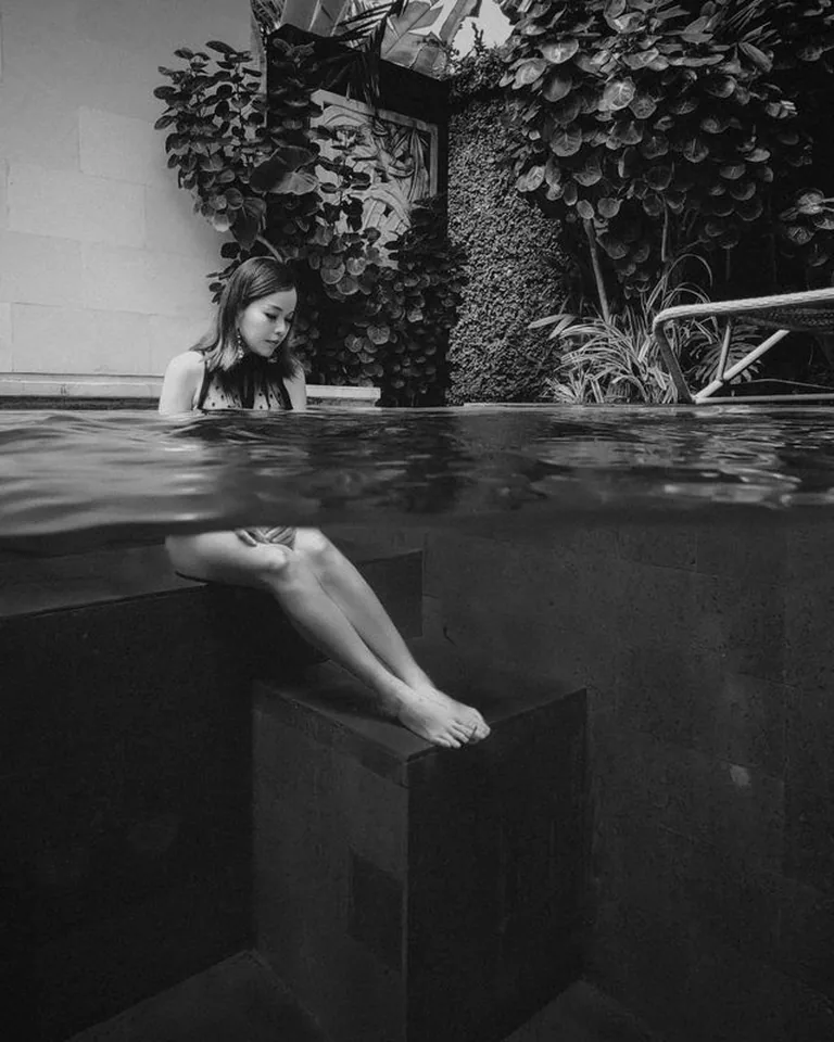 Woman relaxing by the poolside in calm water