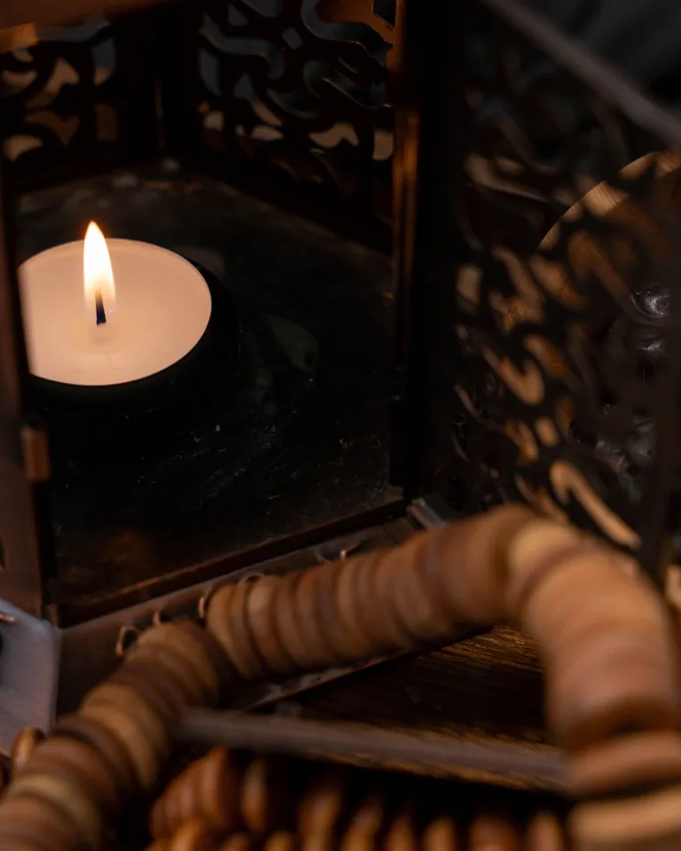 Wax candle glowing in a vintage lantern