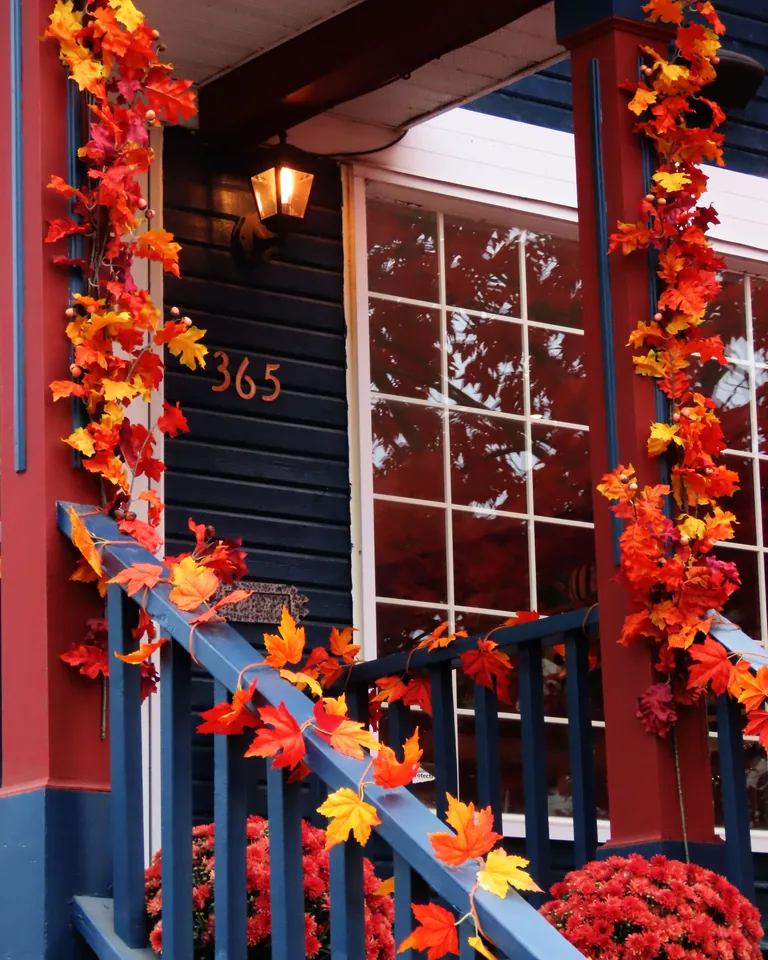 Cozy front porch decorated with vibrant fall maple leaves