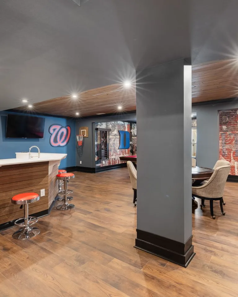 Modern man cave with a sleek bar setup, sports decor and comfortable seating