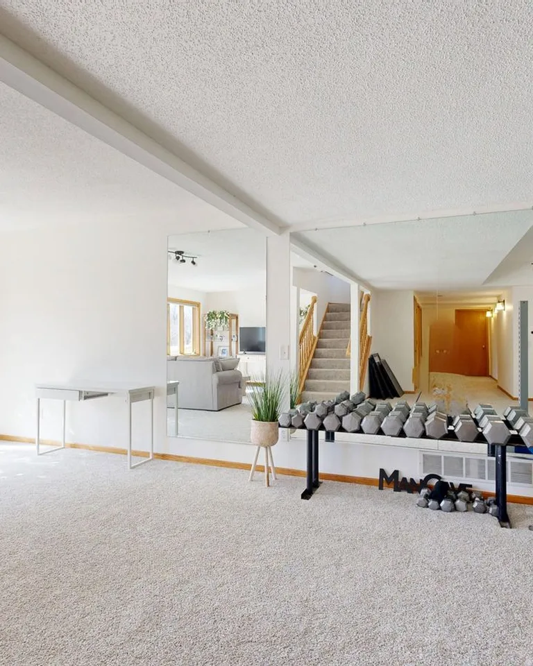 Bright home gym setup with weights, mirrors and modern decor
