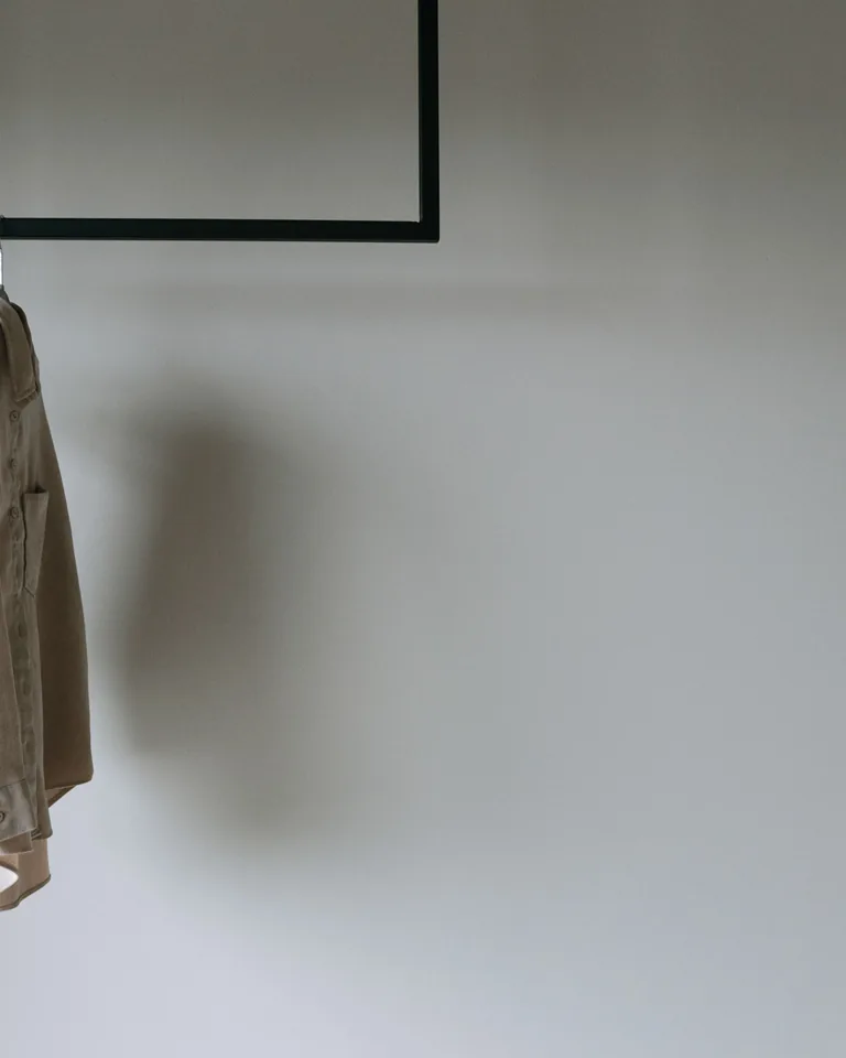 Beige blazer hanging on a minimalist clothing rack