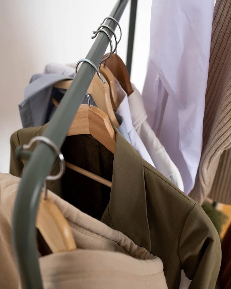 Stylish clothes hanging on a rack in a minimalist room