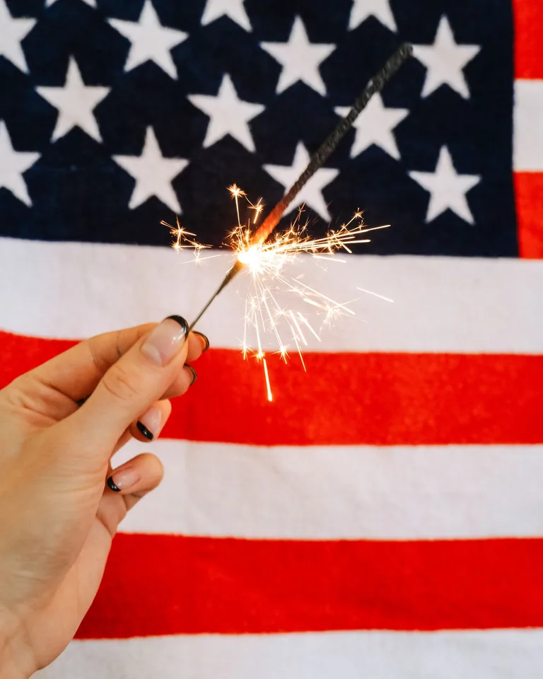 Sparkler held in front of the American flag