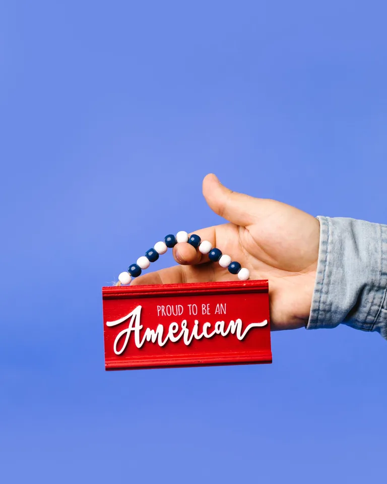 Red American pride sign against a blue backdrop