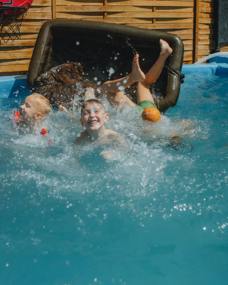 Joyful family playing and splashing in a swimming pool
