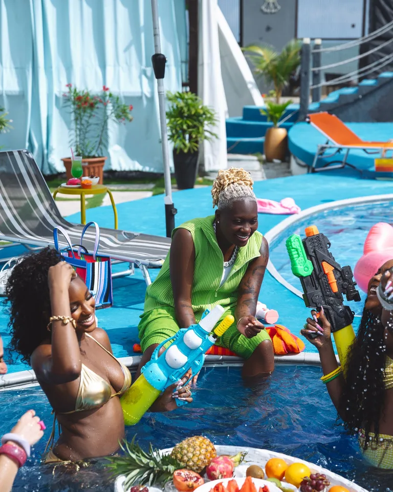 Lively pool party with water guns and fruits under the summer sun