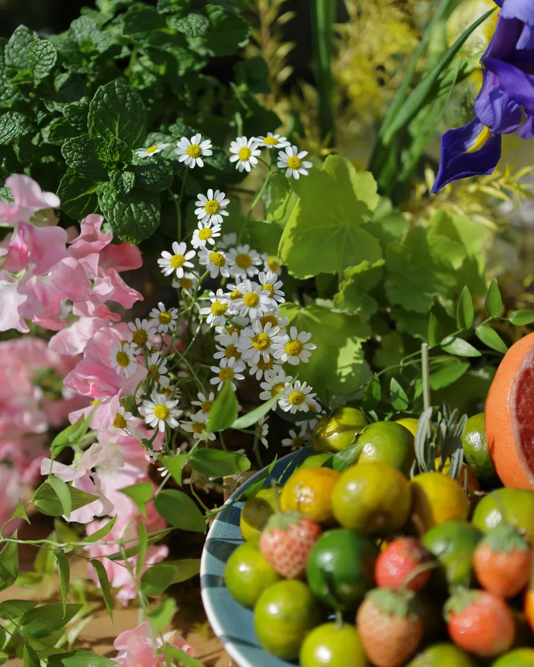 Colorful still life of fresh summer fruits and flowers in natural light