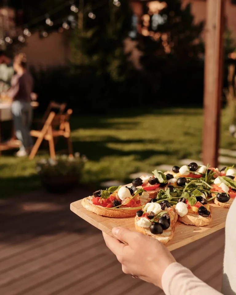 Woman holding a tray of fresh appetizers at a garden party