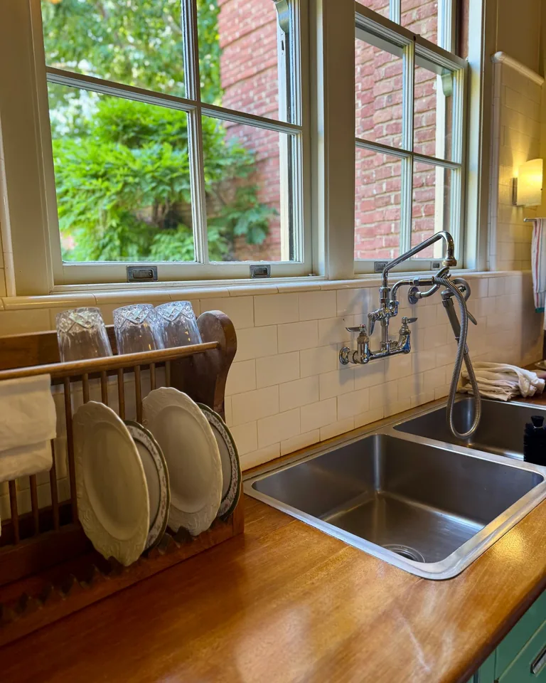 Kitchen sink area styled beside a bright window