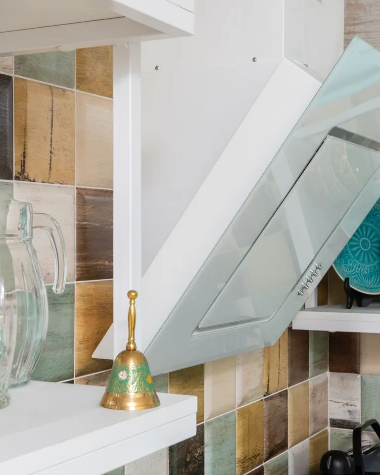 Open kitchen shelves styled with dishware and glass bottles