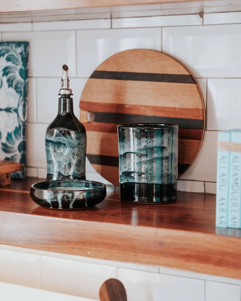 Kitchen shelf styled with glass bottles and wooden decor