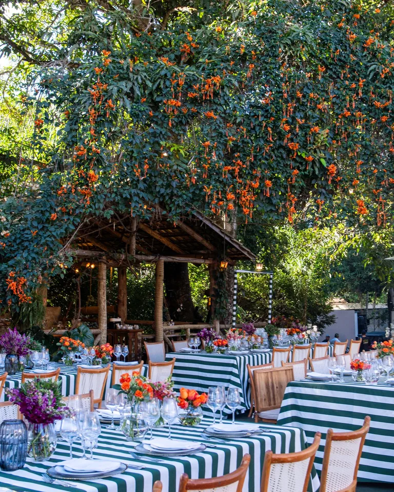 Beautiful outdoor dining area with striped tablecloths and lush floral arrangements